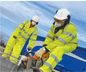 Worker on an exposed roof wearing multiple items of PPE: hi-vis, hard hat, ear defenders and a fall-arrest harness