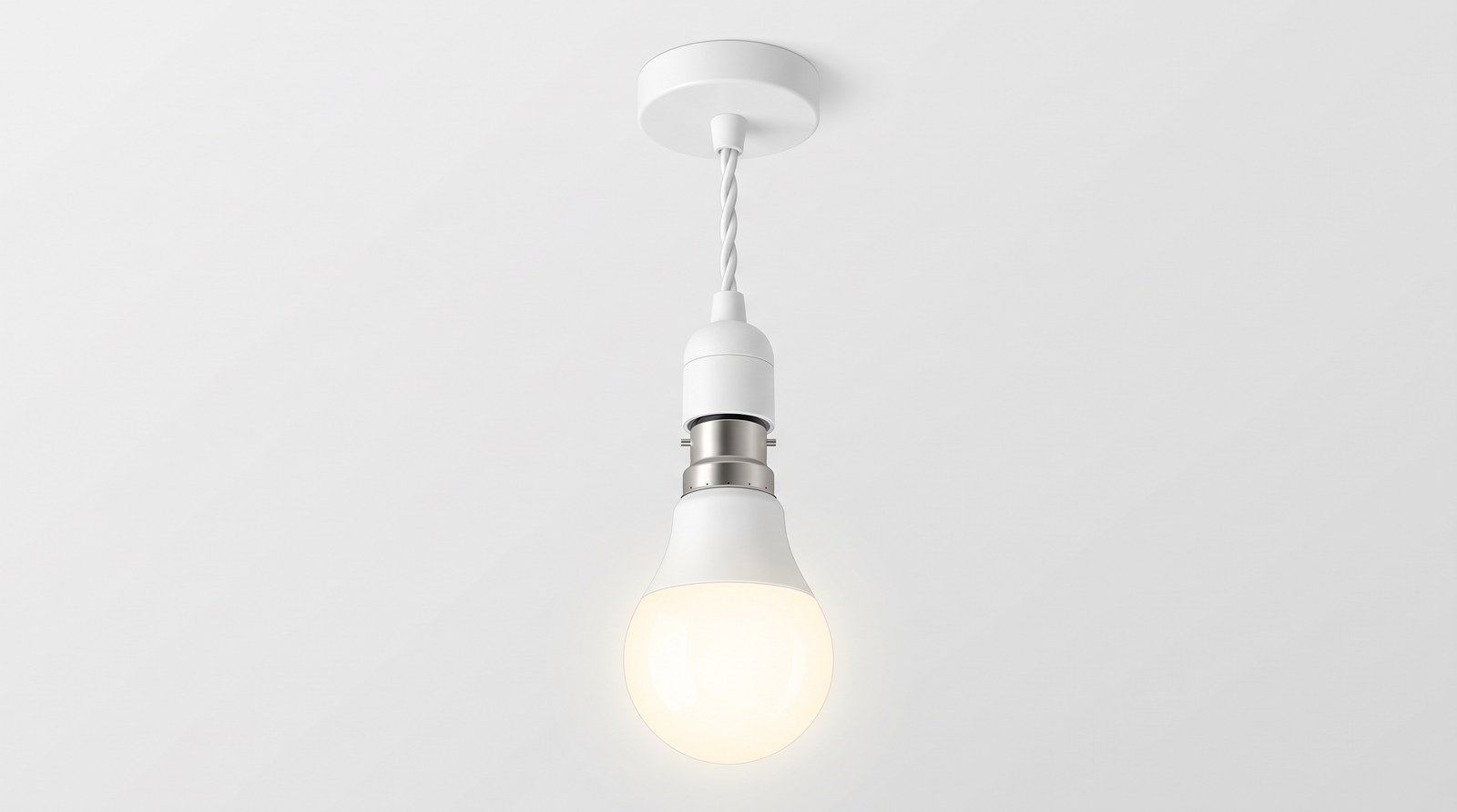An LED light bulb with a bayonet cap glowing in a plain pendant lampholder